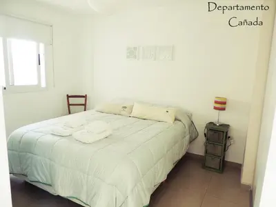a bedroom with a white bed with towels on it at Departamento Cañada Güemes