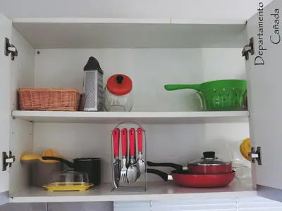 a kitchen shelf with some utensils on it at Departamento Cañada Güemes