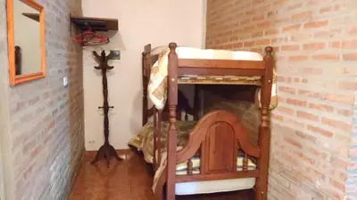 a bunk bed in a room with a brick wall at Cabañas Suave Remanso in Villa Cura Brochero