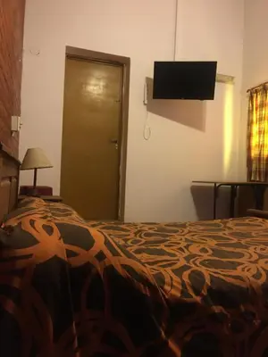 a bedroom with a bed and a flat screen tv at Cabañas Suave Remanso in Villa Cura Brochero