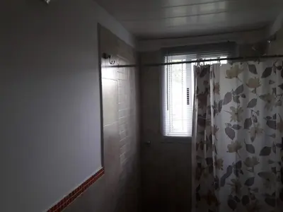a bathroom with a shower curtain and a window at Departamento Estancia Vieja 74 PB in Estancia Vieja