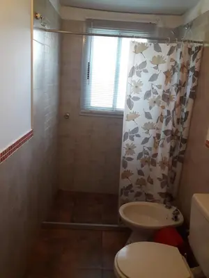 a bathroom with a toilet and a shower curtain at Departamento Estancia Vieja 74 PB in Estancia Vieja