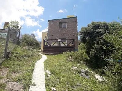 a building on the side of a hill with a path at Departamento Estancia Vieja 74 PB in Estancia Vieja