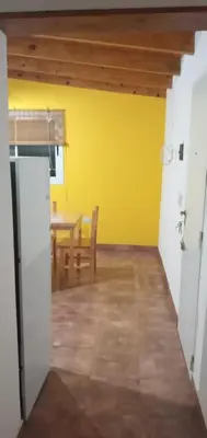 a dining room with a table and a yellow wall at Departamento Estancia Vieja 74 PB in Estancia Vieja