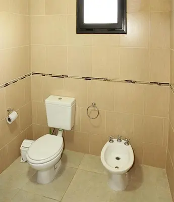a bathroom with a toilet and a bidet at CABAÑAS AGUARI in Santa Rosa de Calamuchita