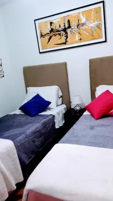 a hotel room with two beds and a painting on the wall at Ignacio Garzón Departamento in Cordoba