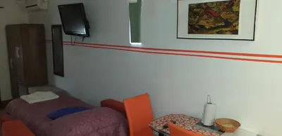a room with a bed and a table and a tv at Ignacio Garzón Departamento in Cordoba