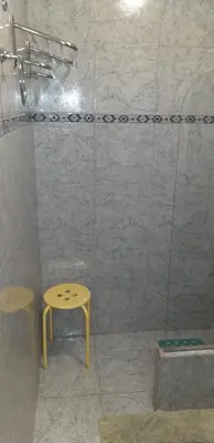 a shower with a yellow stool in a bathroom at Ignacio Garzón Departamento in Cordoba