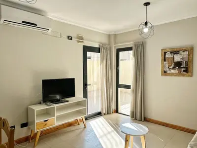a living room with a flat screen tv on a stand at Constantino Iii in Villa Carlos Paz