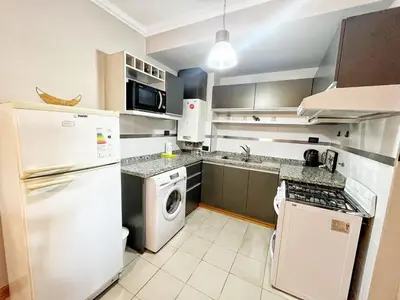 a kitchen with a white refrigerator and a dishwasher at Constantino Iii in Villa Carlos Paz