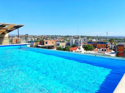 a large blue swimming pool on top of a building at Constantino Iii in Villa Carlos Paz