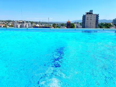 a large pool of blue water with buildings in the background at Constantino Iii in Villa Carlos Paz