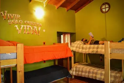 a group of people sleeping in bunk beds in a room at Casa Grande Hostel in Merlo