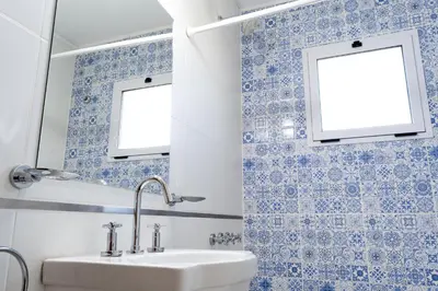 a bathroom with blue and white tiled walls and a sink at Cabañas Doña Juana in Nono