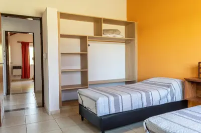 a bedroom with two beds and a closet with shelves at Cabañas Doña Juana in Nono