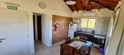 a kitchen with a table and a white refrigerator at Cabañas Doña Juana in Nono