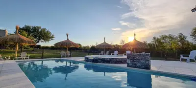 a swimming pool with chairs and umbrellas in a yard at Cabañas Doña Juana in Nono