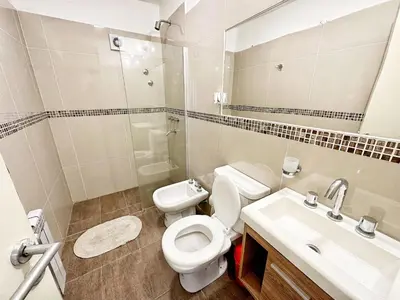a bathroom with a toilet and a sink and a mirror at Vow in Villa Carlos Paz