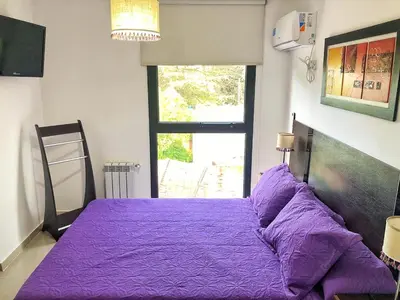 a purple bed in a room with a window at Vow in Villa Carlos Paz