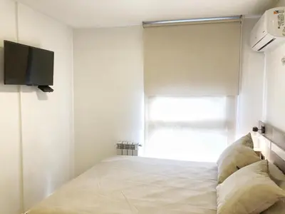 a bedroom with a bed and a tv on the wall at Vow in Villa Carlos Paz