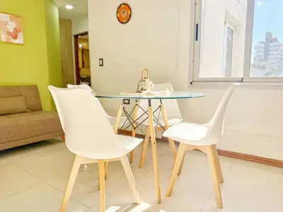 a dining room with a glass table and white chairs at Miralejos Ii in Villa Carlos Paz
