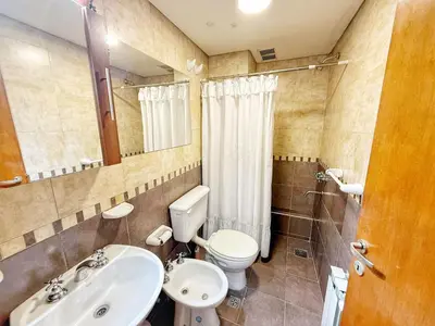 a bathroom with a white toilet and a sink at Miralejos Ii in Villa Carlos Paz