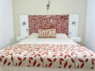 a bedroom with a bed with a red and white bedspread at Awa in Villa Carlos Paz