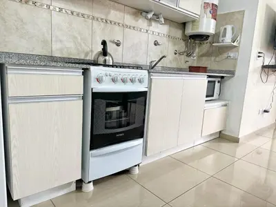 a white kitchen with a stove and a sink at Awa in Villa Carlos Paz