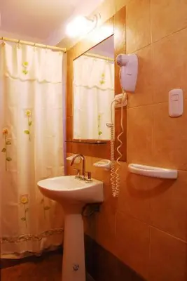 a bathroom with a sink and a mirror and a shower at El Rincón de Iri-Nan in Merlo