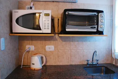 a microwave and a toaster oven on a kitchen counter at El Rincón de Iri-Nan in Merlo