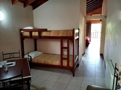 a room with two bunk beds and a table at Posada Los Alamos in Merlo