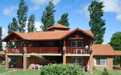 a large house with a balcony and a deck at Posada Los Alamos in Merlo
