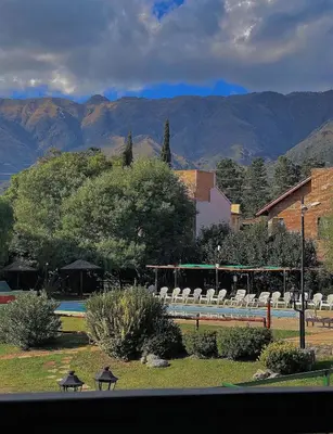 a group of chairs in a park with mountains in the background at Posada Los Alamos in Merlo
