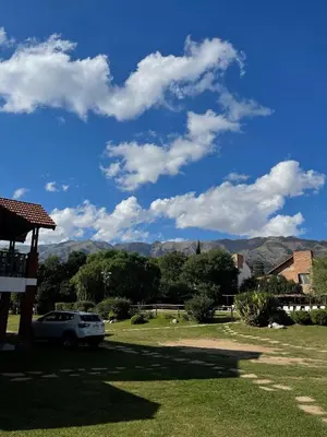a car parked in a yard with mountains in the background at Posada Los Alamos in Merlo