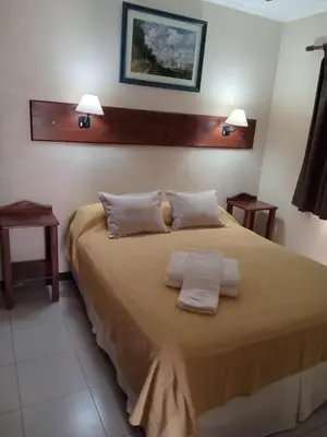 a bedroom with a large bed with two towels on it at Posada Los Alamos in Merlo