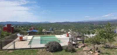 a house with a swimming pool on a hill at Estancia de Campo in Estancia Vieja