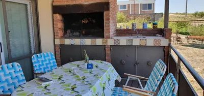 a table and chairs on a balcony with a fireplace at Estancia de Campo in Estancia Vieja