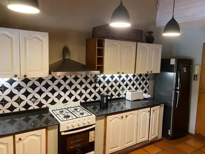 a kitchen with white cabinets and a black refrigerator at Casa en Córdoba Zona Norte in Cordoba