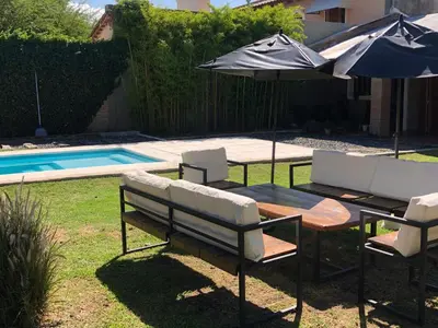 a table and chairs with an umbrella next to a pool at Casa en Córdoba Zona Norte in Cordoba