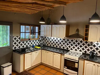 a kitchen with white cabinets and black counter tops at Casa en Córdoba Zona Norte in Cordoba