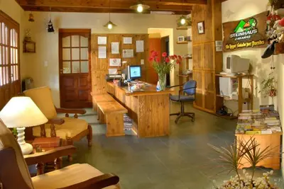 a living room with a desk and chairs and a room at Cabañas Steinhaus in Villa General Belgrano