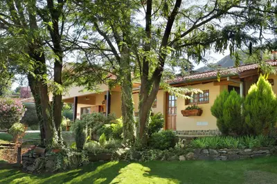 a house with trees and a yard at Cabañas Steinhaus in Villa General Belgrano