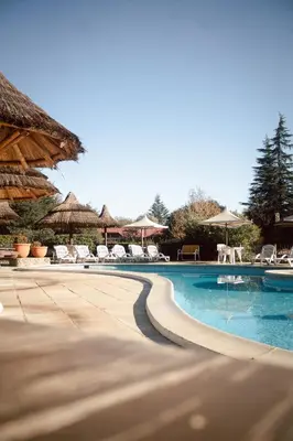 a swimming pool with chairs and umbrellas at Cabañas Steinhaus in Villa General Belgrano