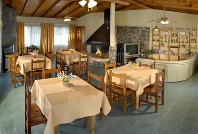 a restaurant with tables and chairs and a fireplace at Cabañas Steinhaus in Villa General Belgrano