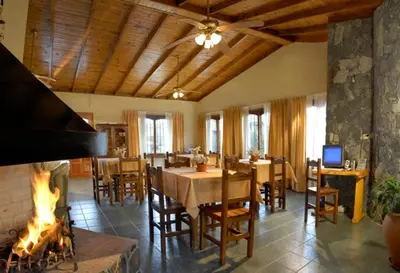 a dining room with a table and a fireplace at Cabañas Steinhaus in Villa General Belgrano