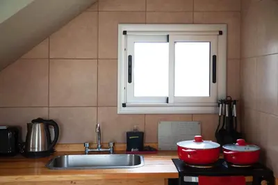 a kitchen with two pots and a sink and a window at Cabaña Anita in Merlo