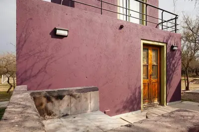 a pink building with a wooden door on it at Cabaña Anita in Merlo