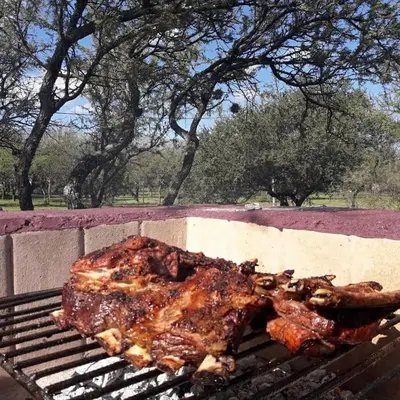 a piece of meat is cooking on a grill at Cabaña Anita in Merlo