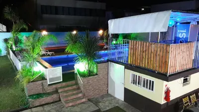 a building with a swimming pool at night at HOTEL COLONIAL in Villa Carlos Paz