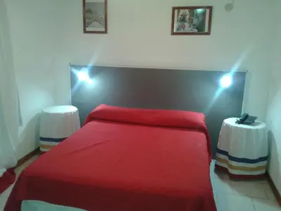 a bedroom with a red bed with lights on it at HOTEL COLONIAL in Villa Carlos Paz